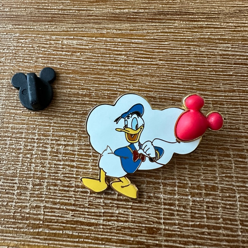 Donald Duck holding red Mickey Mouse balloon